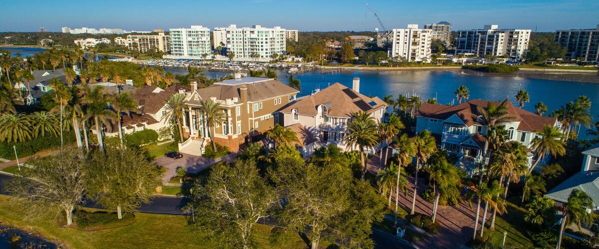 A coastal residential area with beachfront properties, a marina, and high-rise hotels.