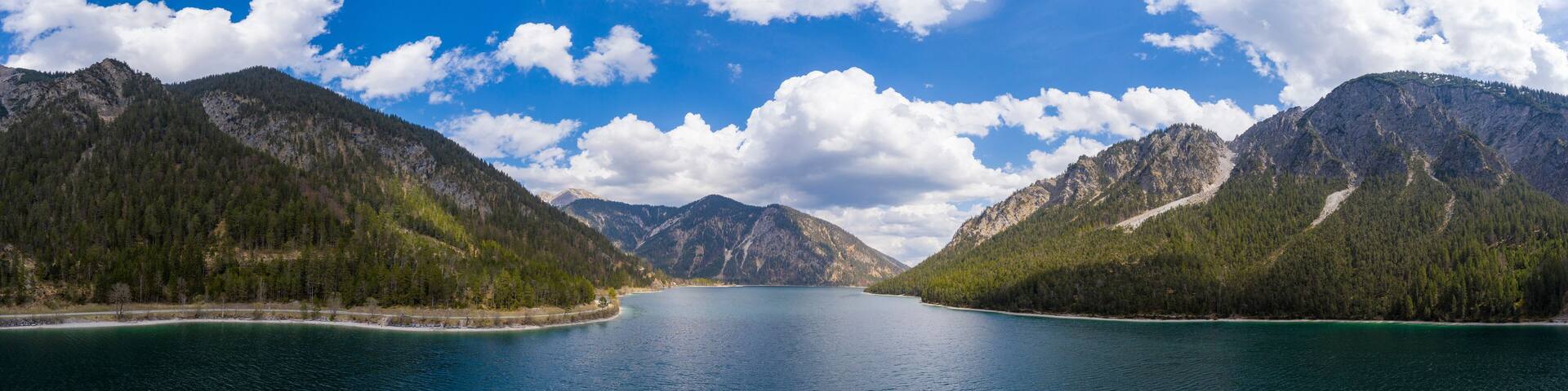 panorama of lake plansee at spring day with blue cold water in austria tirol