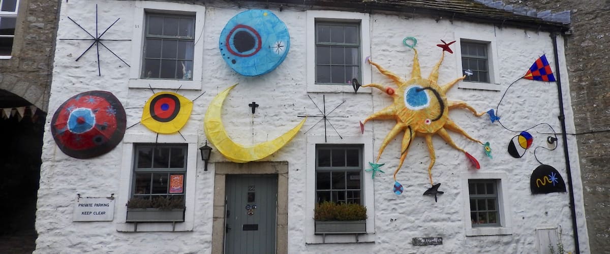 A white building with colorful decorations including a sun, moon, and various shapes.