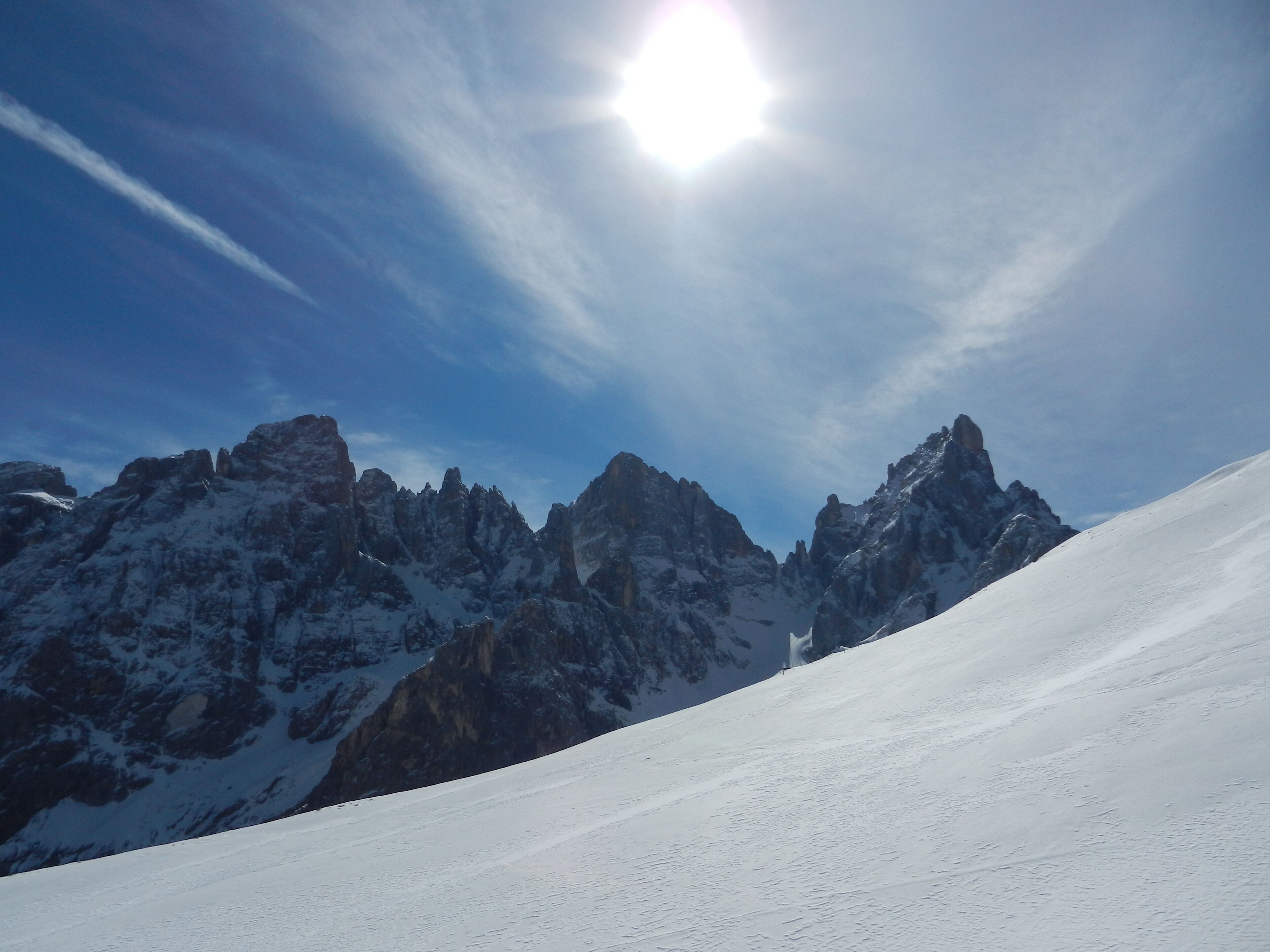 Cordilheira nevada com picos pontudos sob um céu limpo.