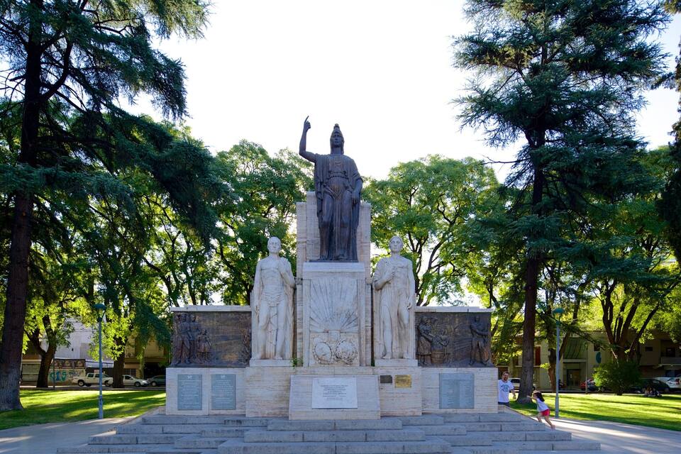 Eine Statue einer historischen Persönlichkeit, umgeben von Bäumen in einem Park.
