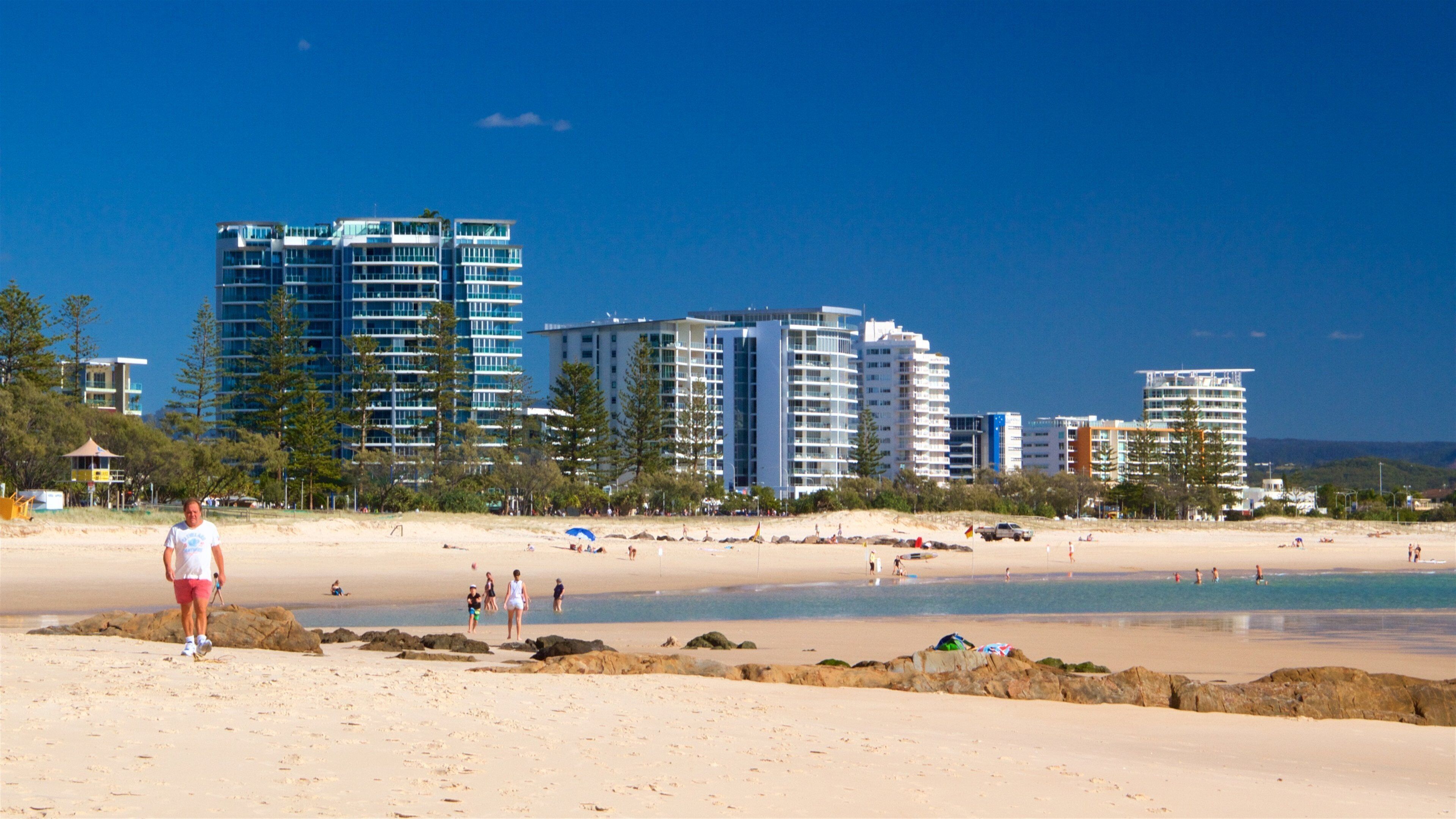 Coolangatta Beach toont een zandstrand, algemene kustgezichten en een stad