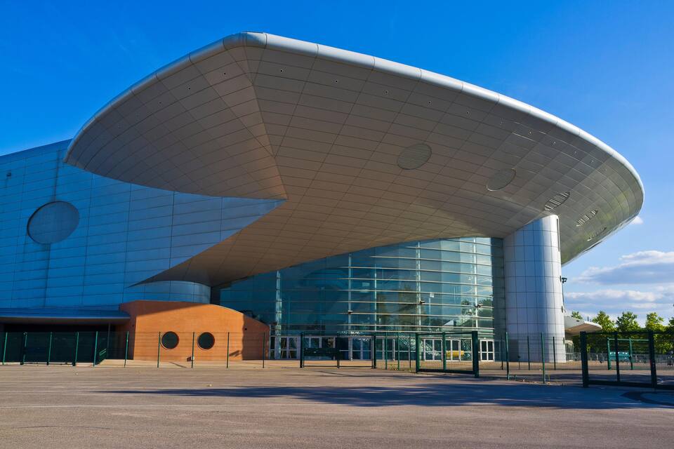 A modern building with a curved roof and large glass windows.