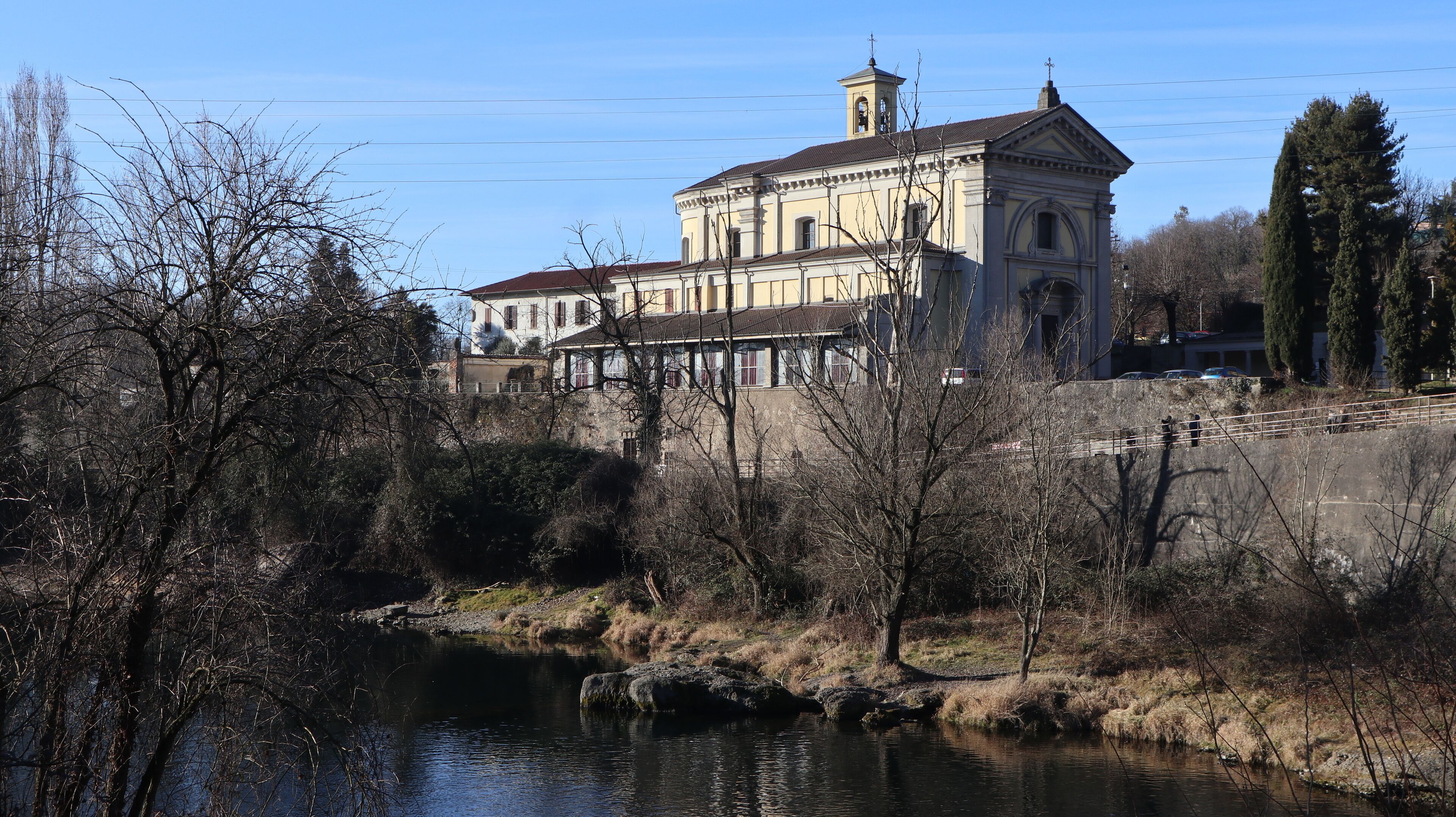 A historic building with a large tower and a river in the foreground.