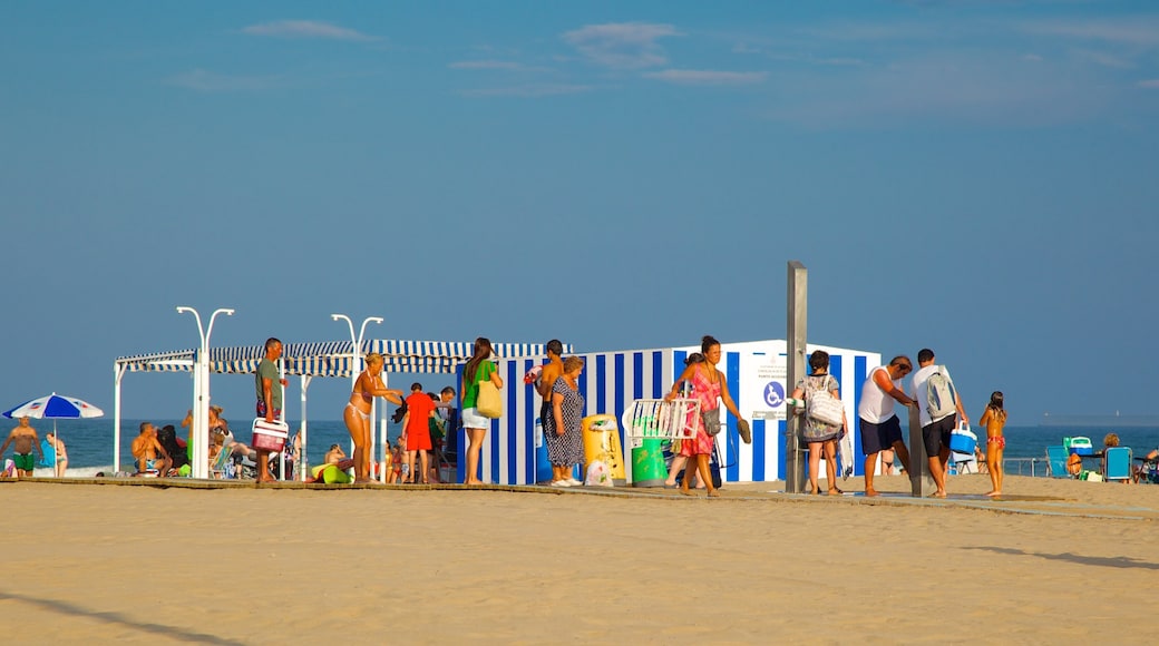 Malvarrosa Beach showing a beach as well as a large group of people