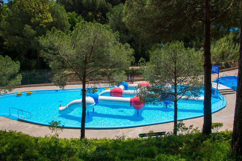 Una piscina con scivoli e cerchi gonfiabili.