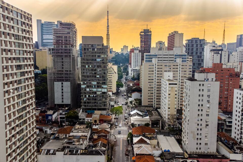 Un paisaje urbano con rascacielos, una calle despejada y un cielo al atardecer.