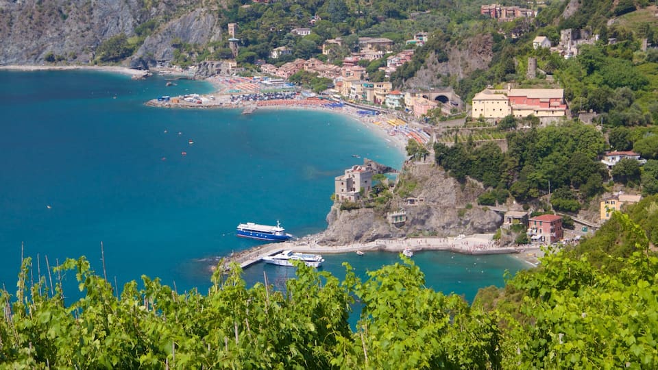 A coastal town with a beach, boats, and a castle-like structure on a cliff.