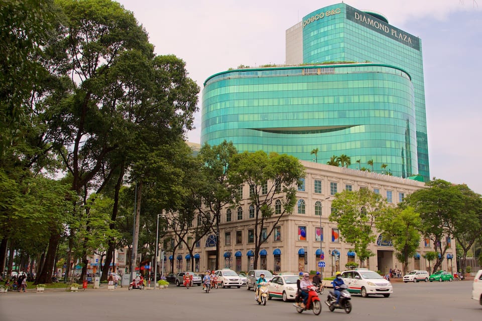 Um edifício moderno com fachada de vidro curva e uma placa com o nome 'Diamond Plaza'.