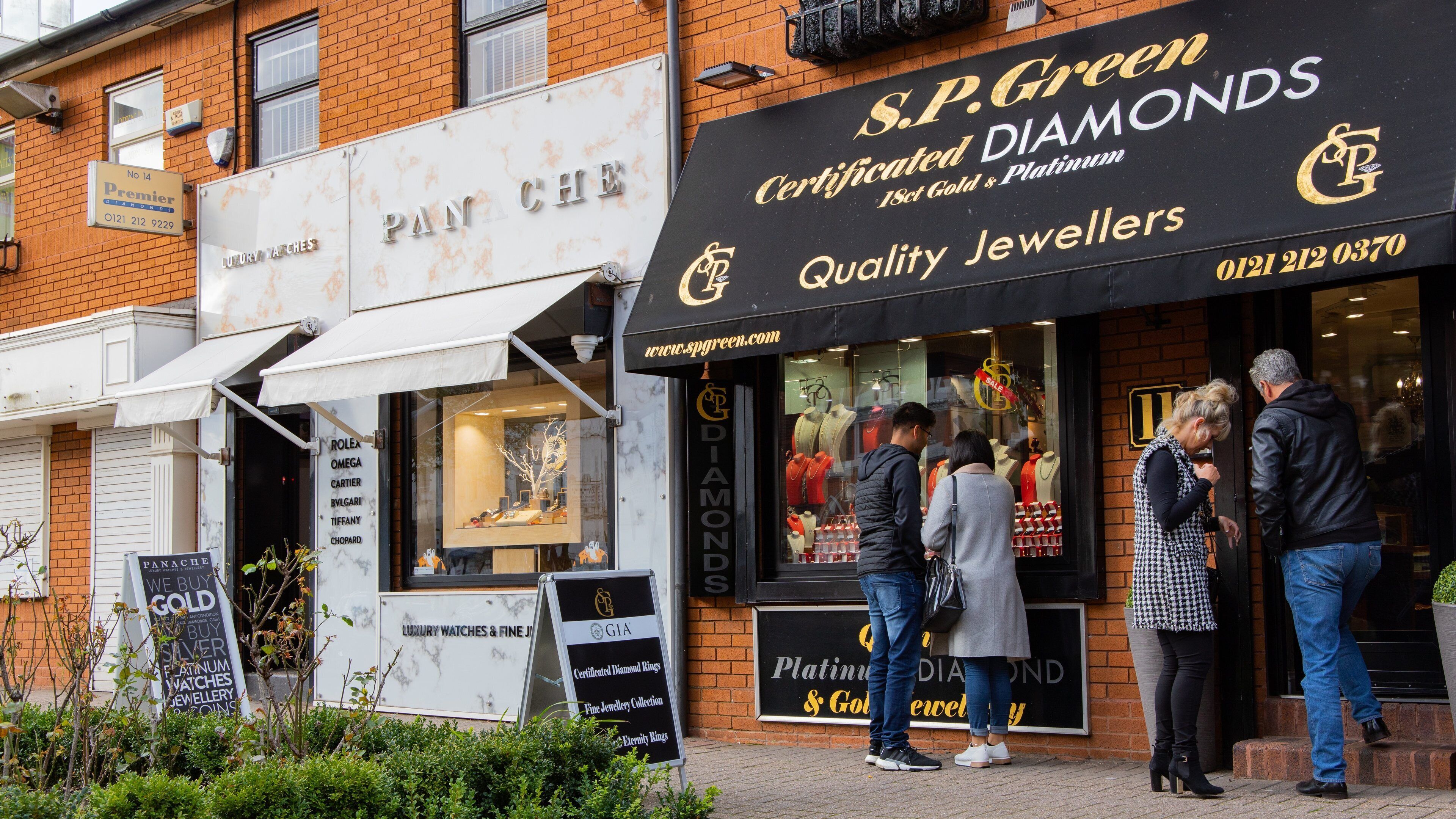 A storefront with a sign for S.P. Green, a jeweler specializing in certified diamonds.