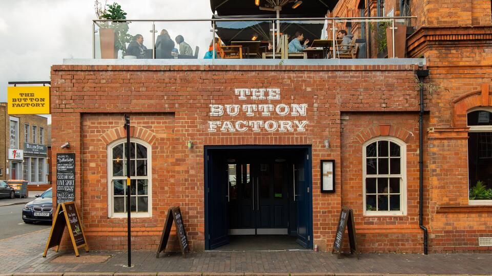 The Button Factory, a brick building with a black door and arched windows.