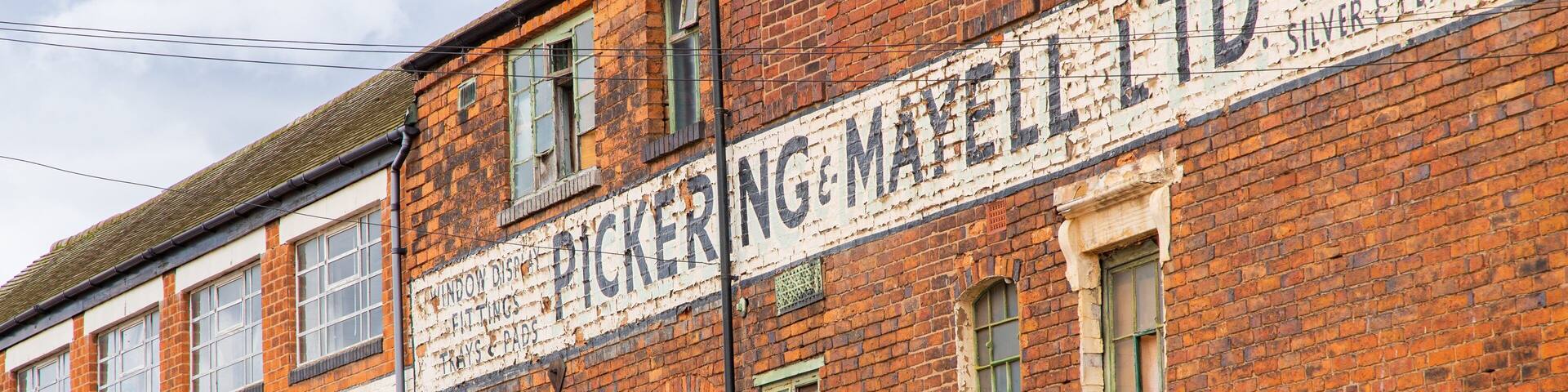 A brick building with signs for 'Pickering & Mayell Ltd.' and 'Cases for Jewellery Silver & Plate'.