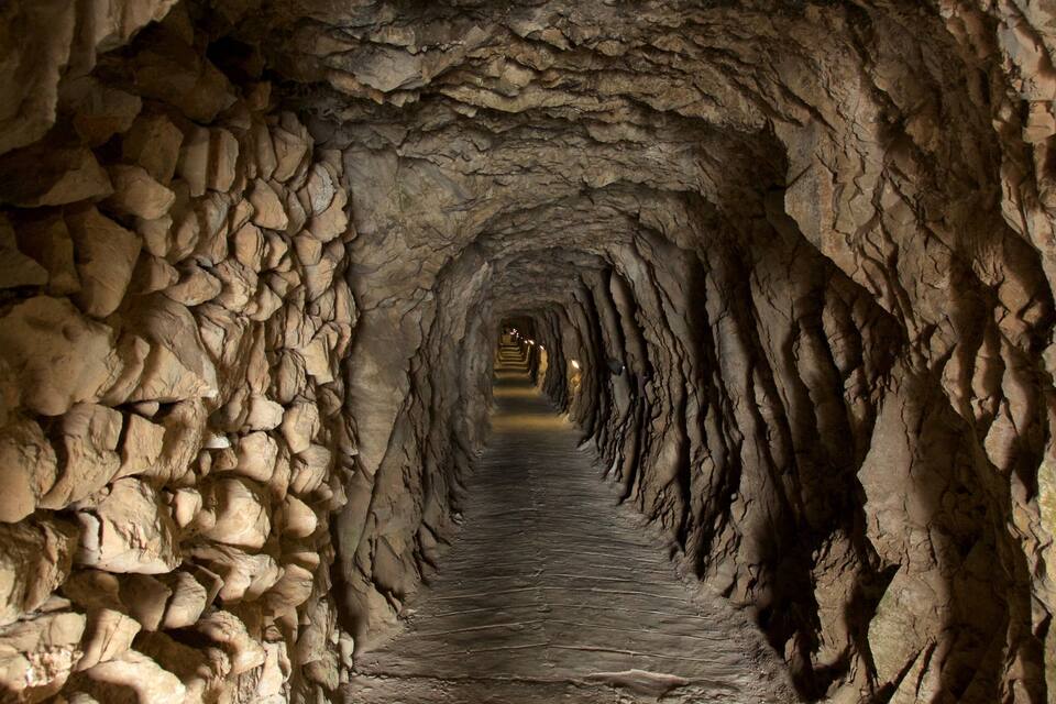 Un túnel de piedra con un sendero estrecho y sinuoso.