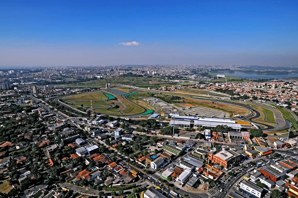 An aerial view of a city with a large racetrack surrounded by residential and commercial buildings.