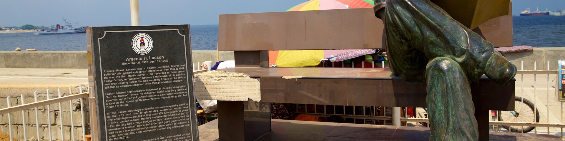 Manila Bay featuring a statue or sculpture and signage