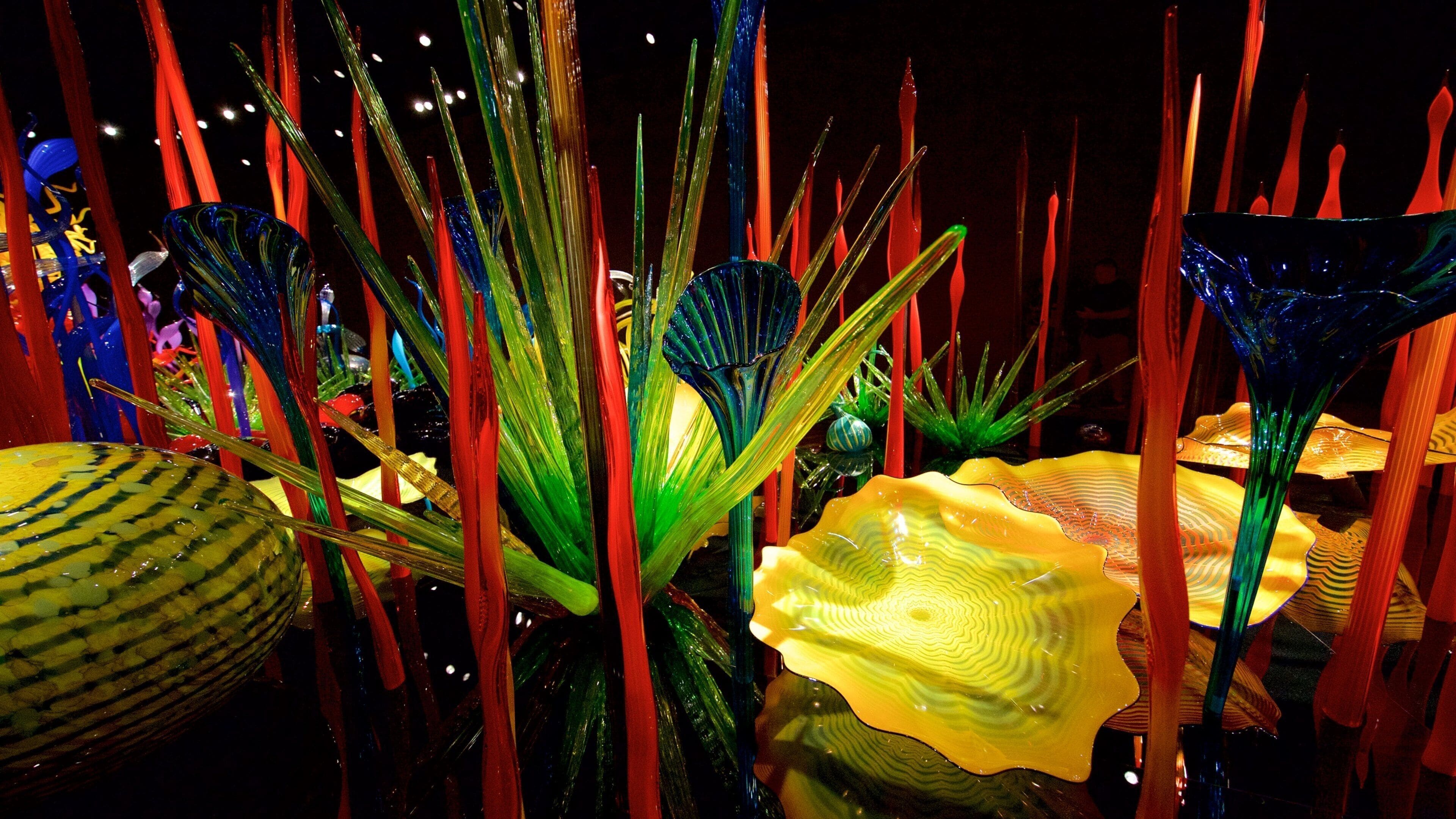 Esculturas de vidrio coloridas en un entorno oscuro.