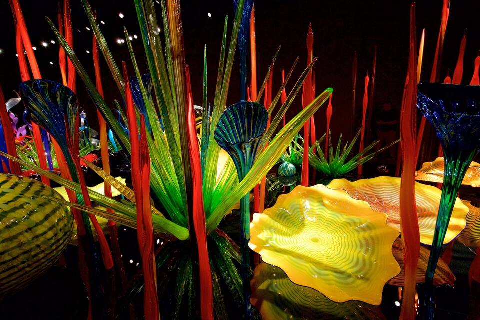 Esculturas de vidrio coloridas en un entorno oscuro.