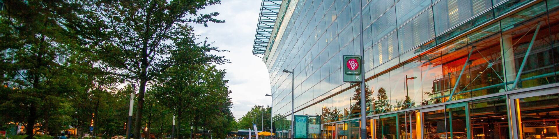 A modern building with glass windows and a green signboard.