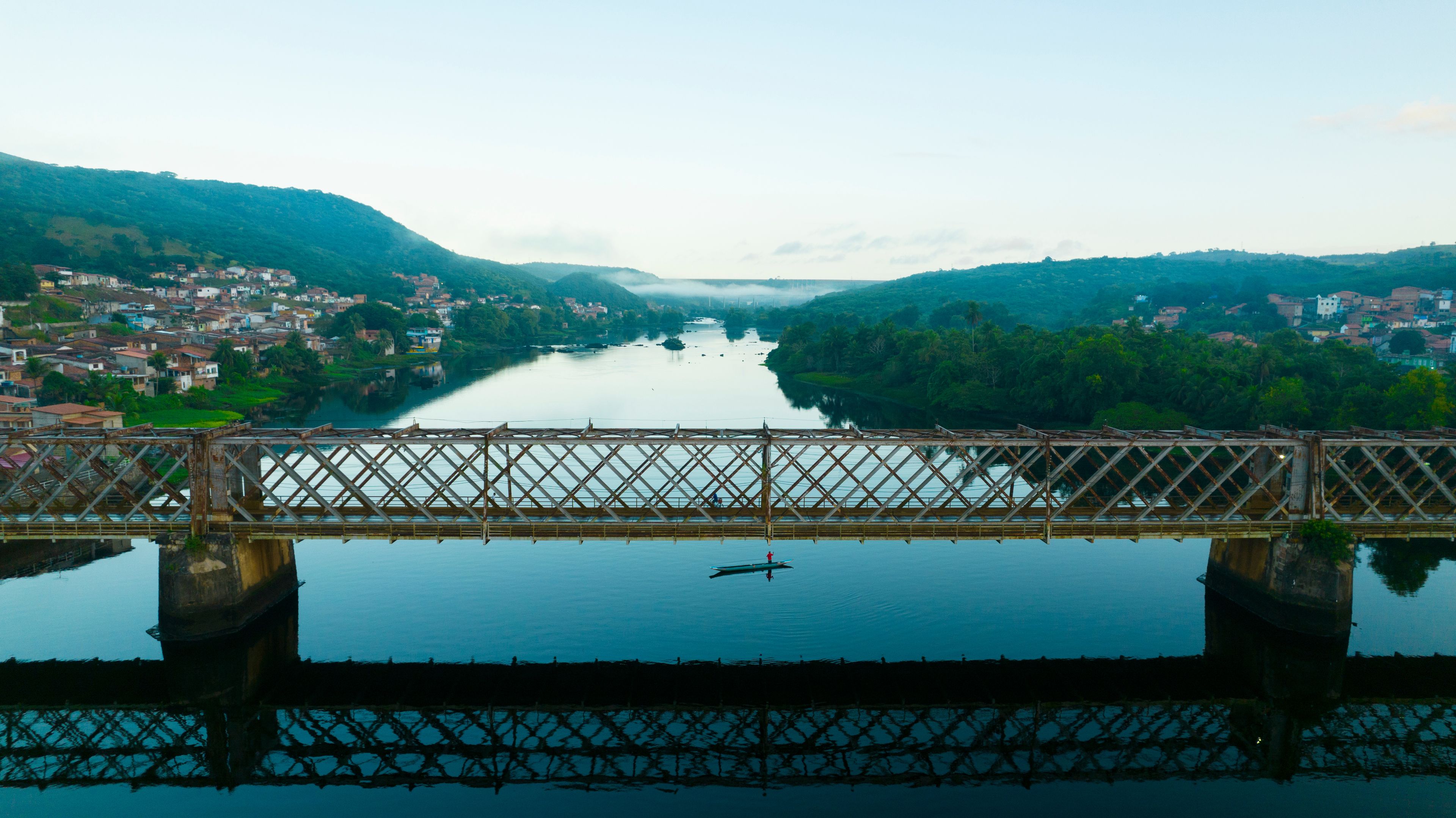 A bridge over a river with a town in the background.