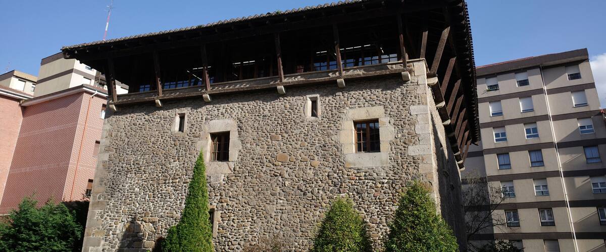 A stone building with a tiled roof and several windows.