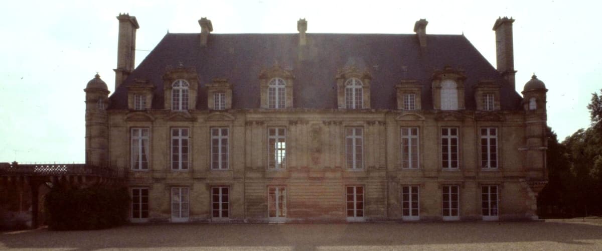 A large, historic building with multiple windows and a symmetrical facade.
