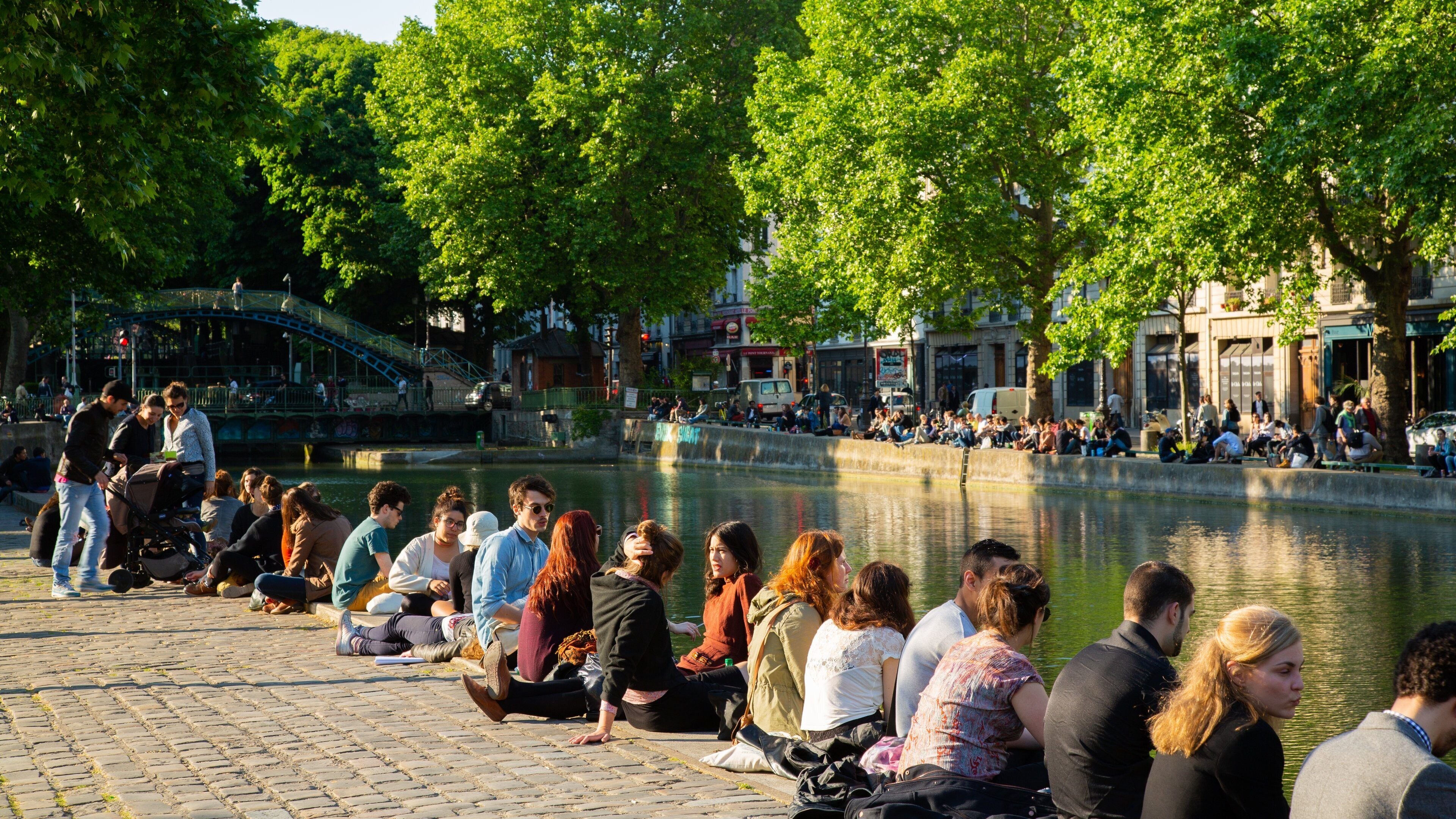 Canal Saint-Martin featuring a river or creek as well as a small group of people