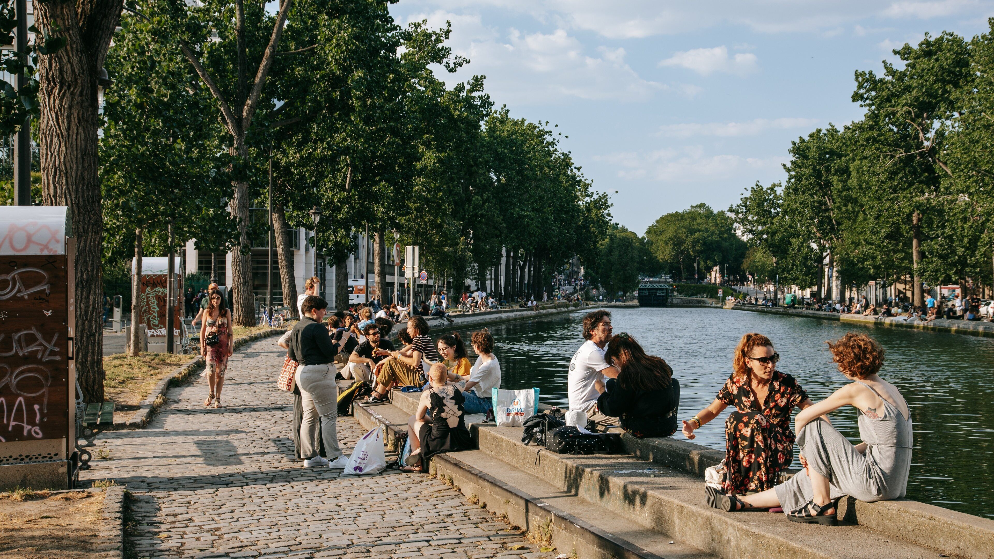 Canal Saint-Martin showing a river or creek and a bay or harbor as well as a small group of people
