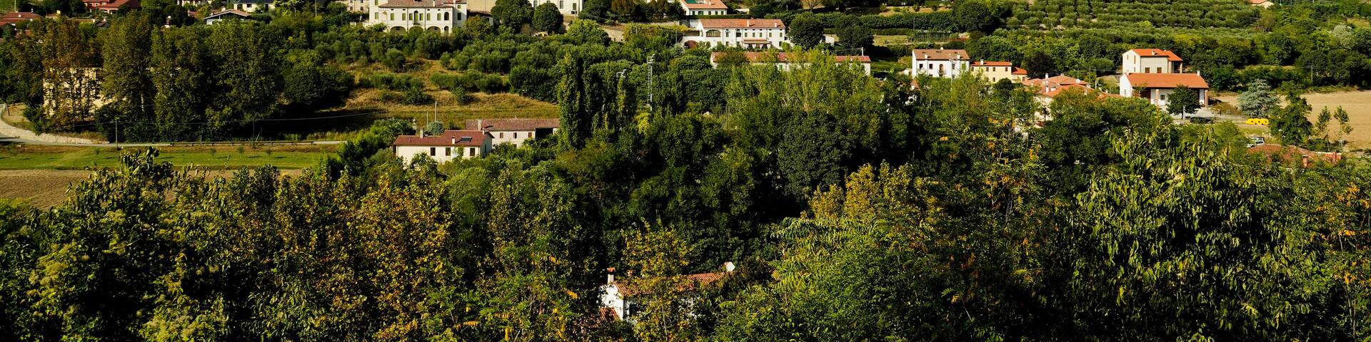 A village with a prominent church and rolling hills in the background.