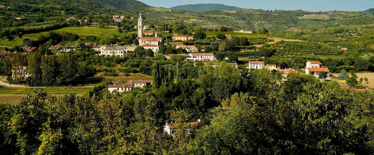 A village with a prominent church and rolling hills in the background.