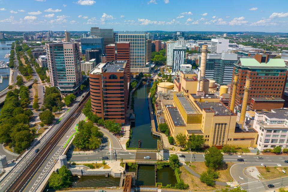 Paisagem urbana com rio, edifícios modernos e uma ponte.