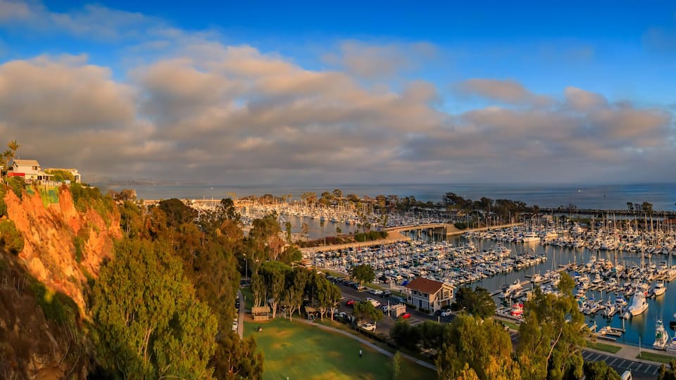 Sunset over luxury homes, yachts, and boats in Dana Point harbor, Orange County in Southern California on a cloudy day