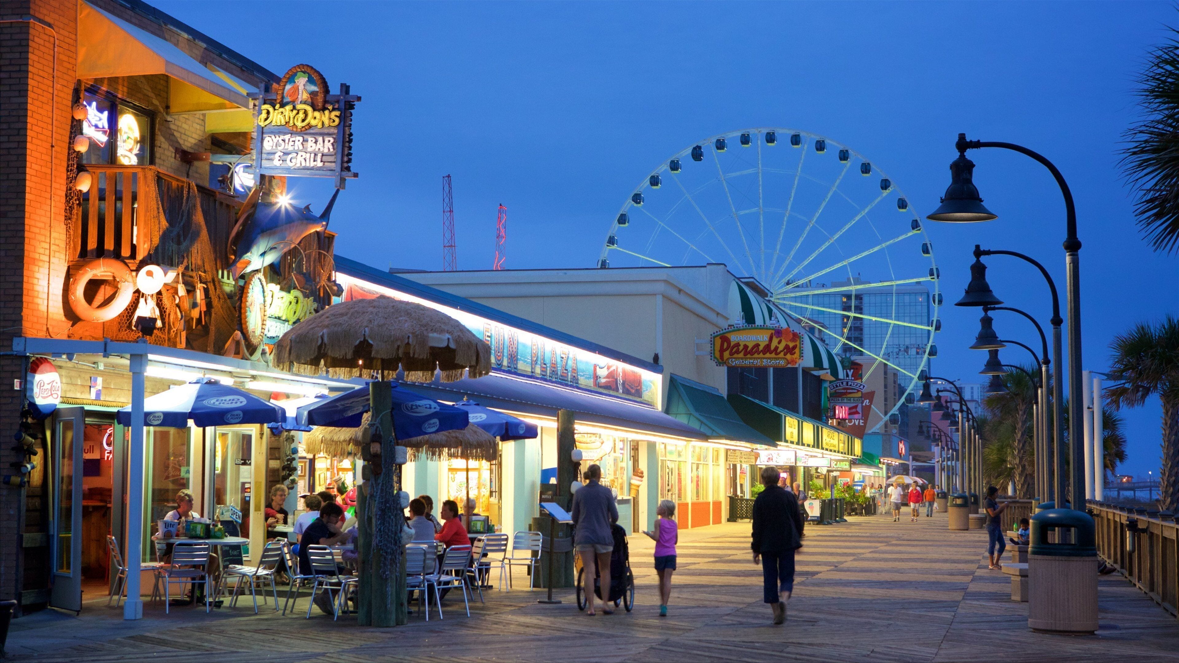 Myrtle Beach Boardwalk featuring signage, outdoor eating and night scenes