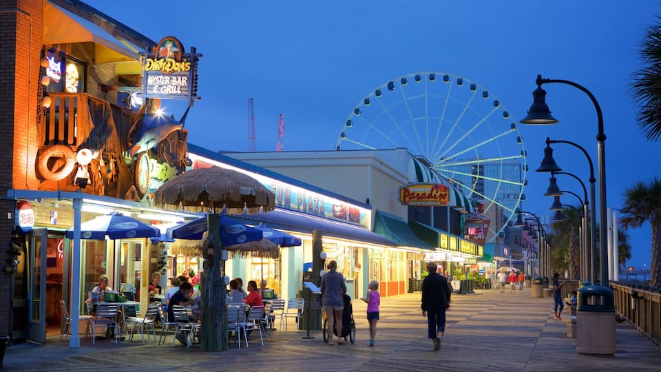 Myrtle Beach Boardwalk featuring signage, outdoor eating and night scenes