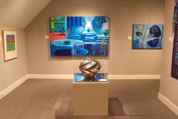 Uma galeria de arte com diversas pinturas e esculturas.