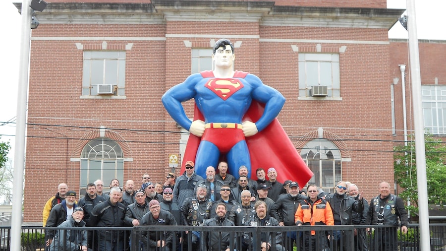 Superman Statue bevat een standbeeld of beeldhouwwerk en ook een klein groepje mensen