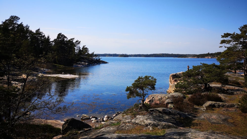 A calm lake surrounded by rocky shores and dense trees.