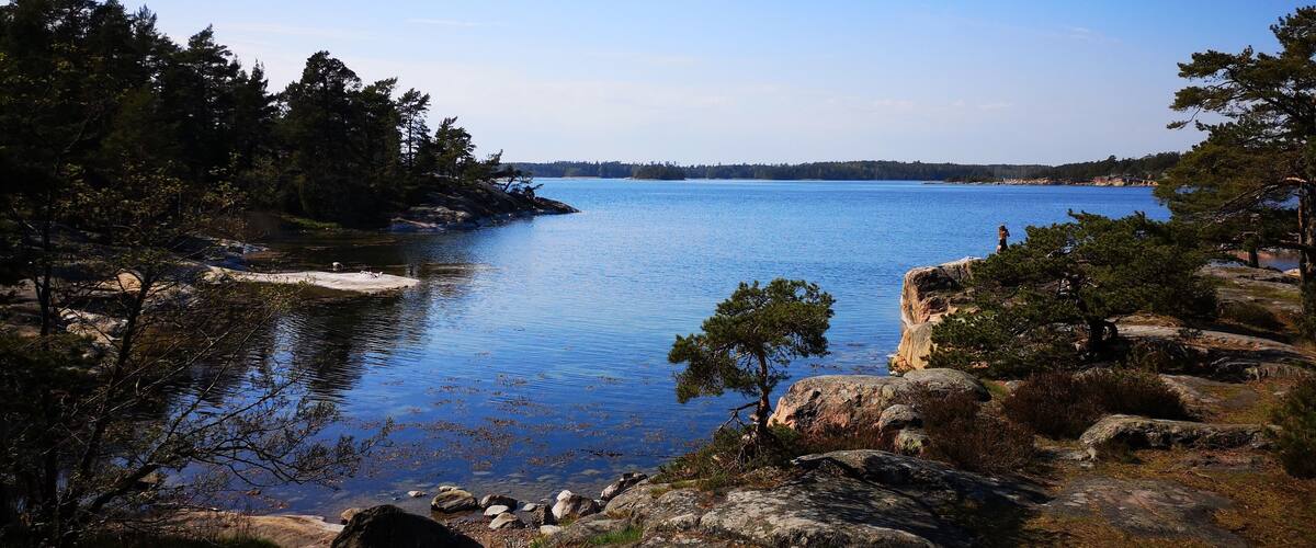 A calm lake surrounded by rocky shores and dense trees.