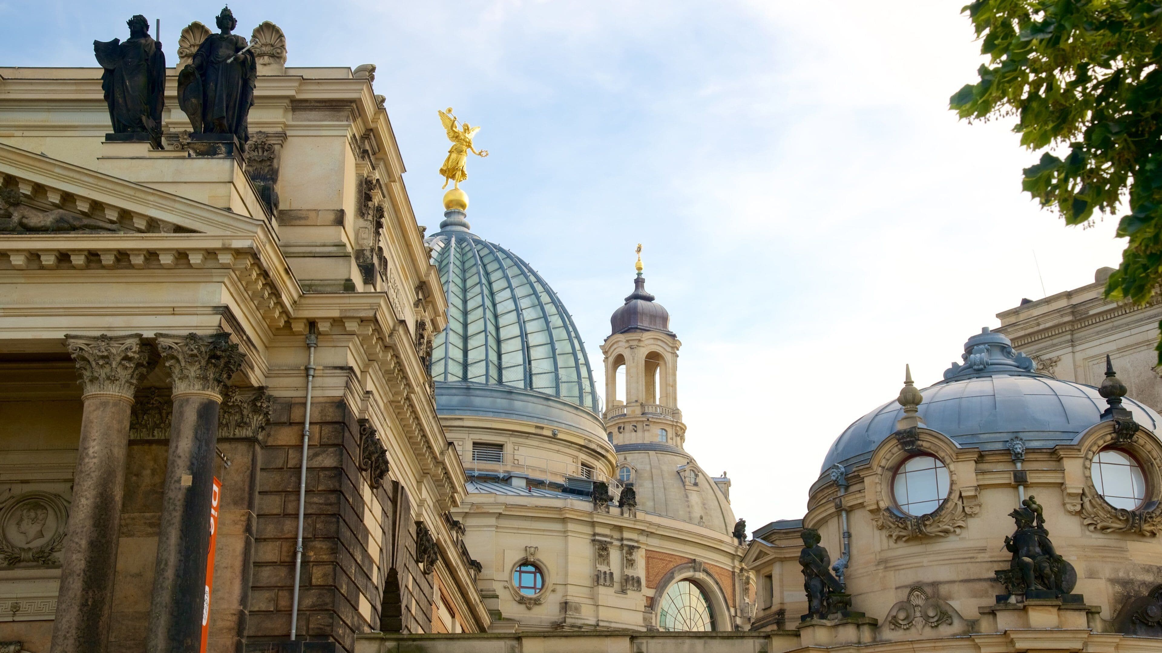 A historic building with ornate architecture, including a large dome and statues.