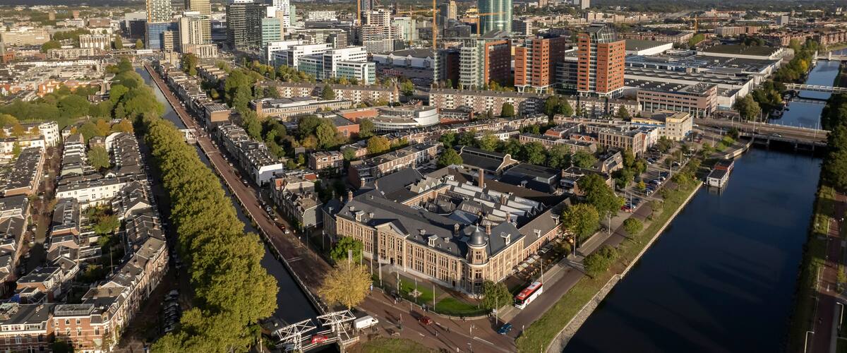 Muntgebouw and skyline of Dutch city Utrecht with financial and central train station area in the background with canal and floating homes in the foreground