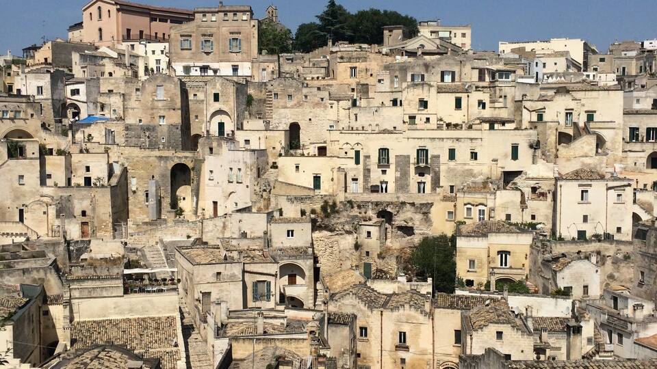 A densely packed hillside town with historic buildings and terraced rooftops.
