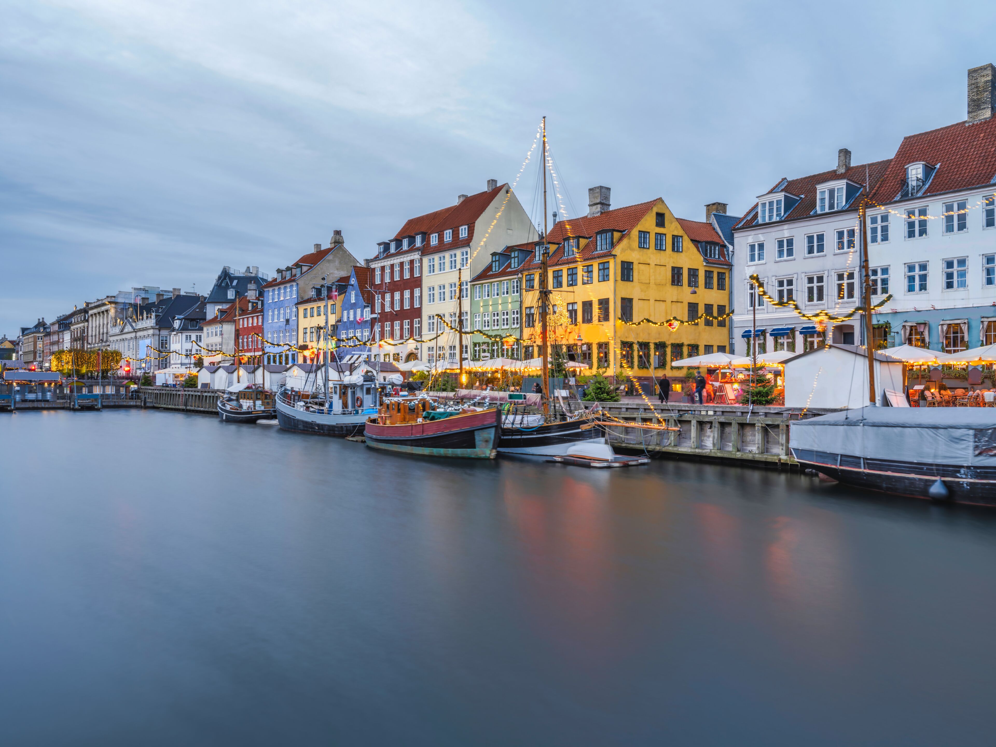Nyhavn harbour lit up with Christmas lights at dusk, Copenhagen, Denmark