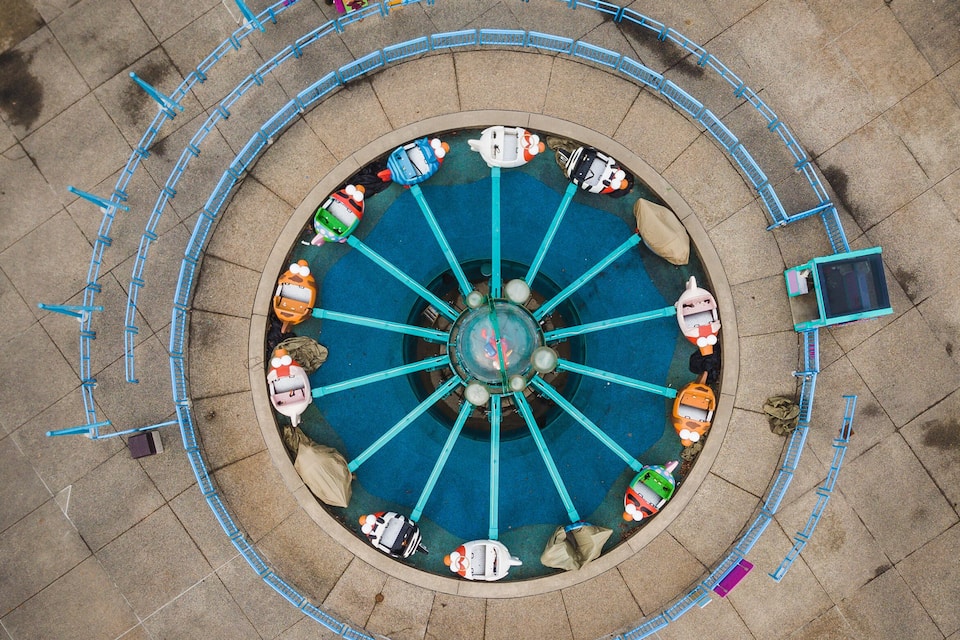 A circular water fountain with multiple jets and colorful boats.