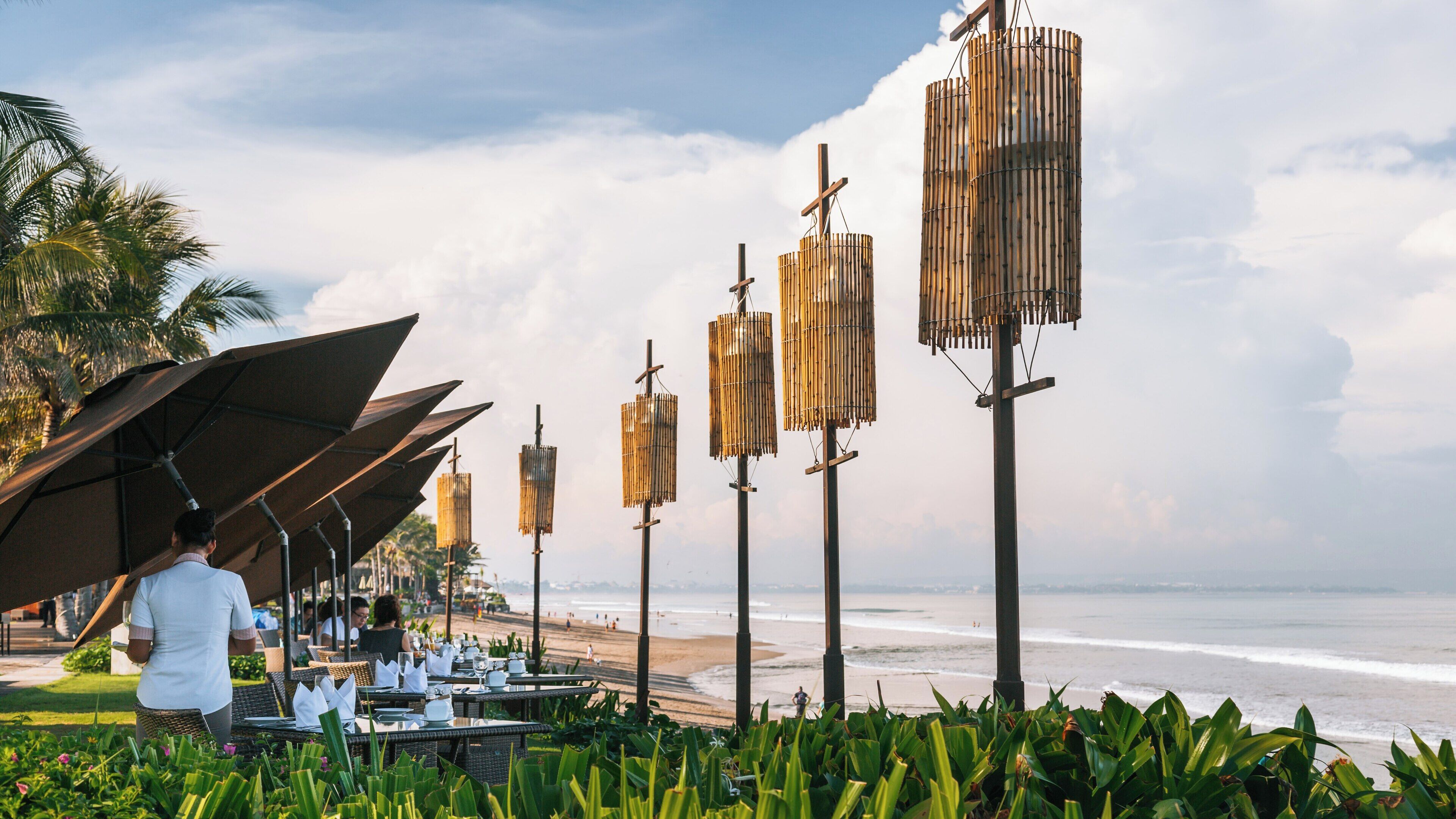 Enjoying the serene beauty of Seminyak Beach with dining experiences along the shoreline in Kuta Utara, Bali, Indonesia during a calm day