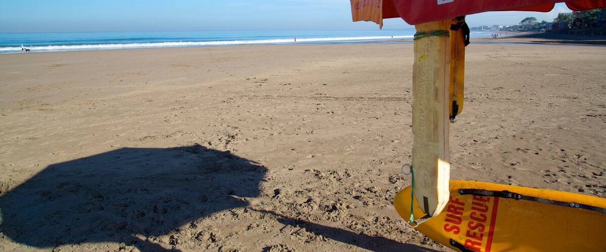 A lifeguard stand on a beach with a clear view of the ocean and distant shoreline.
