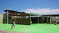 A green artificial turf area with a sign reading "TERRA NATURA" and a covered structure with a roof.