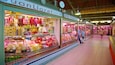 A market with various food items on display, including cheeses and meats.