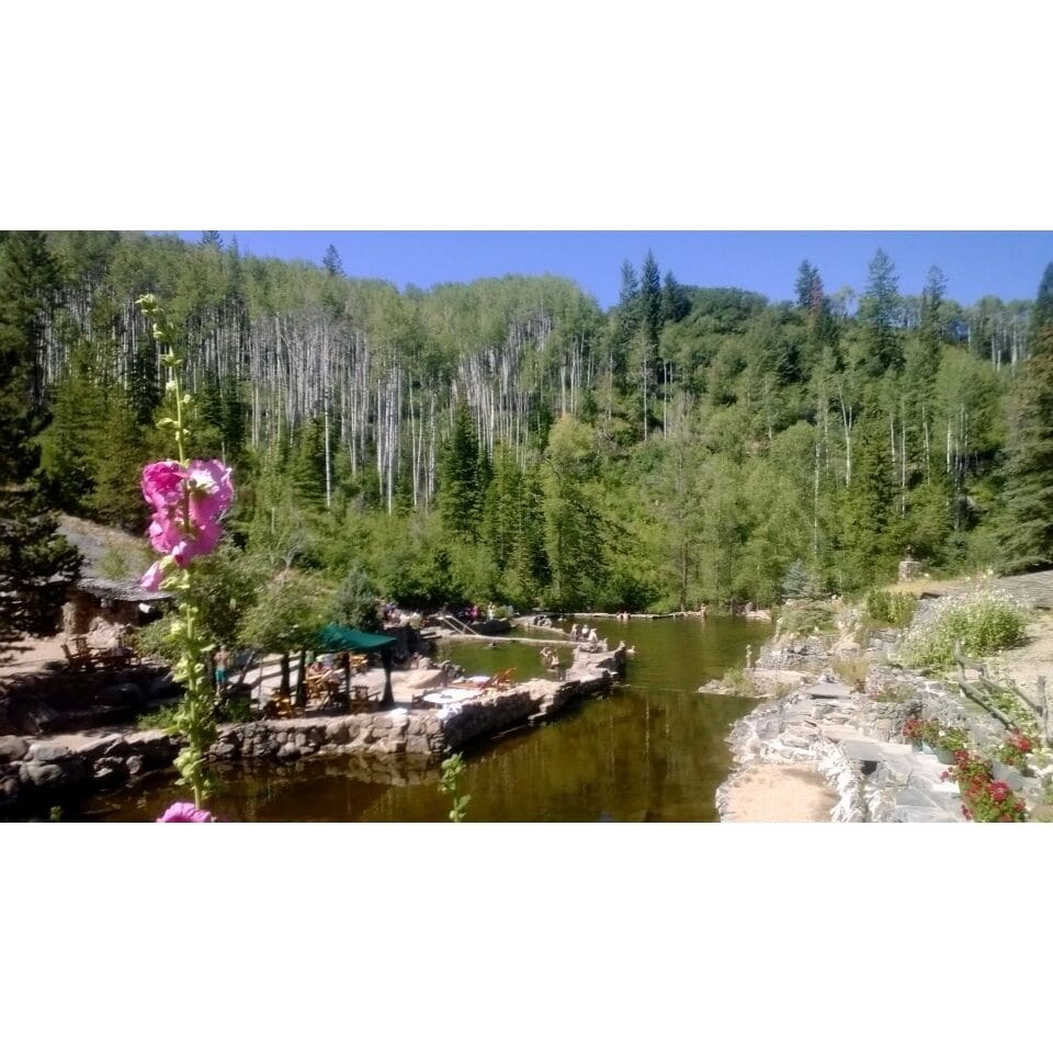 A forested area with a river and a rocky outcrop.