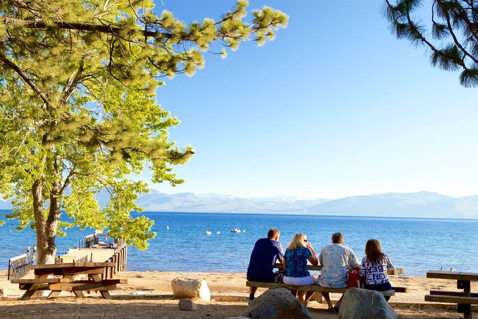 A beach with a clear view of the sea and mountains in the background.