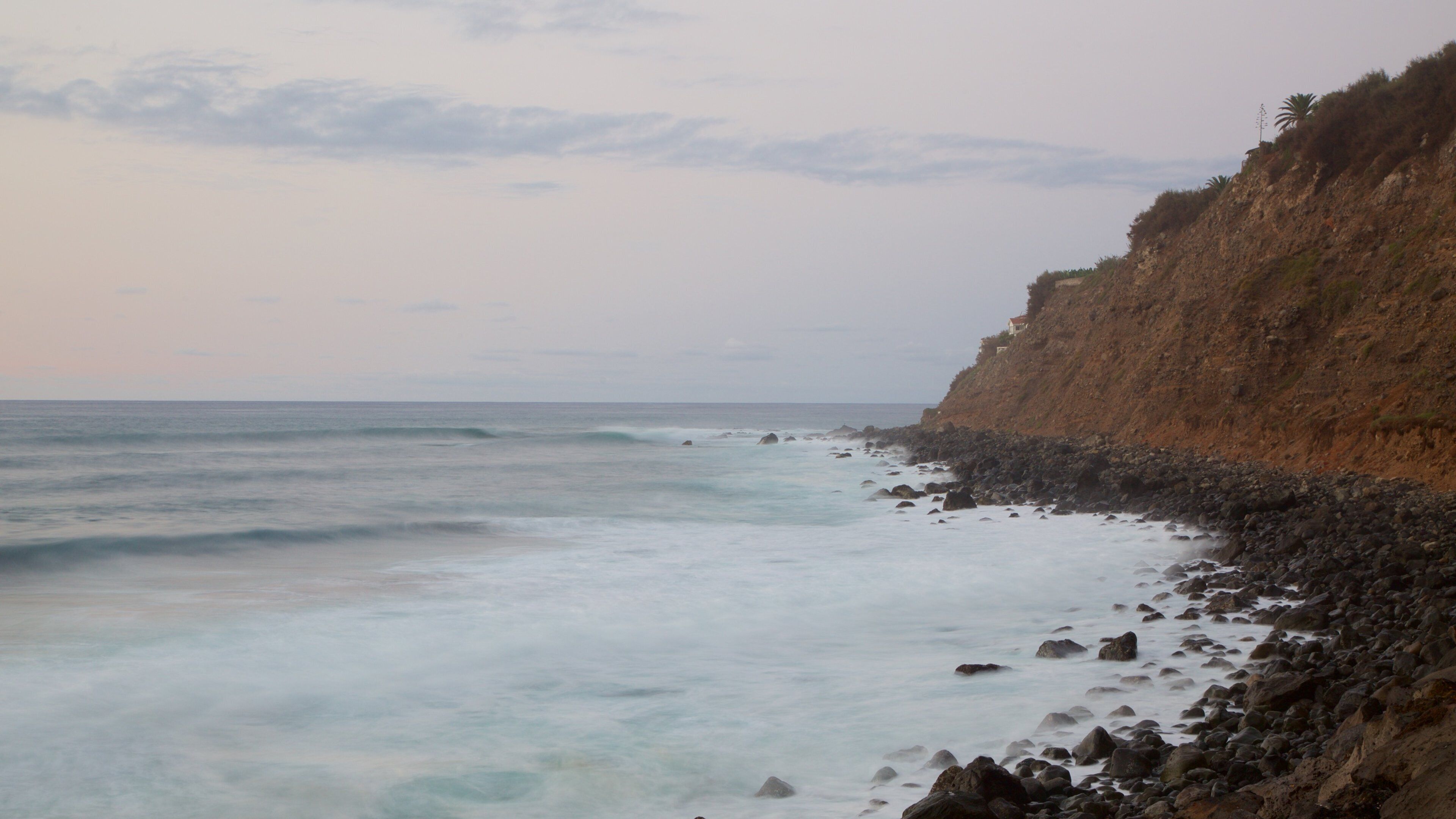 El Socorro Strand som viser klippekystlinje, en stenstrand og udsigt over kystområde