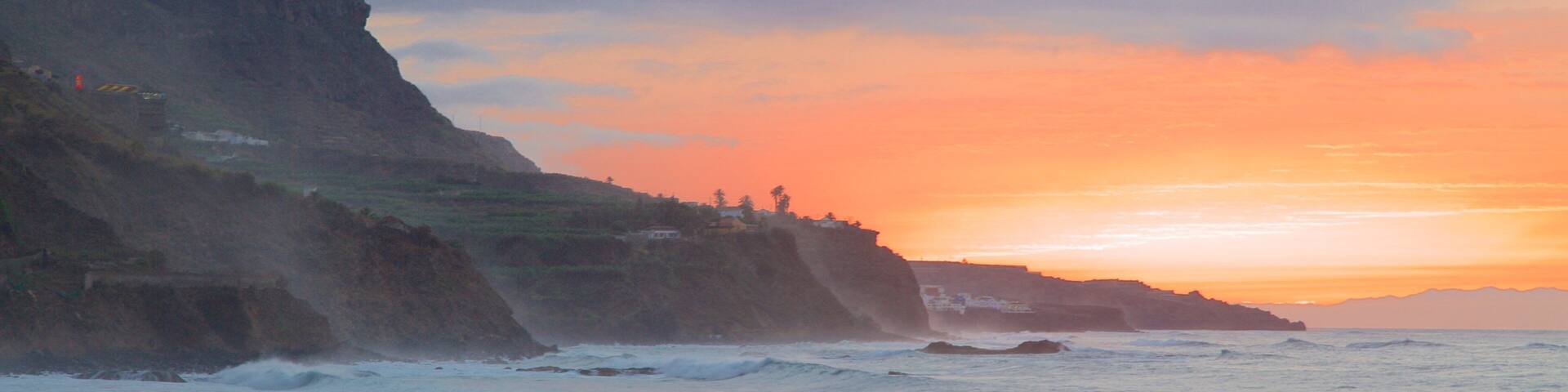 El Socorro Beach showing rocky coastline, a sunset and general coastal views